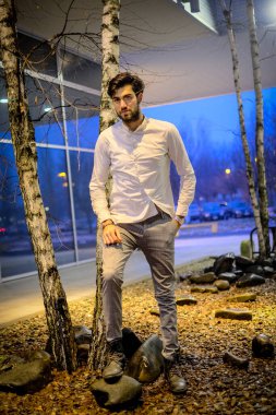 Beyaz gömlekli yakışıklı, koyu renk saçlı adam. Yüksek kalite fotoğraf