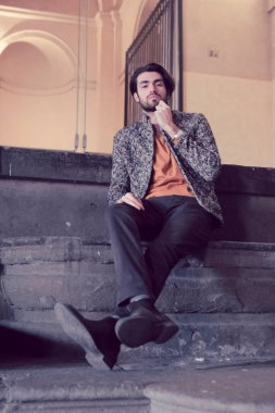 Parma 'daki Pilotta' nın merdivenlerinde oturan yakışıklı siyah saçlı çocuk. Yüksek kalite fotoğraf