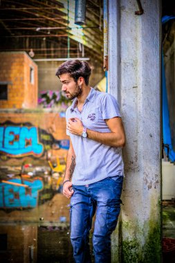 Dejenere olmuş terk edilmiş fabrikadaki yakışıklı siyah saçlı İtalyan adam. Yüksek kalite fotoğraf