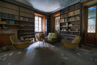 Büyük terk edilmiş evde eski kitap ve dergilerle dolu bir kütüphane. Yüksek kalite fotoğraf