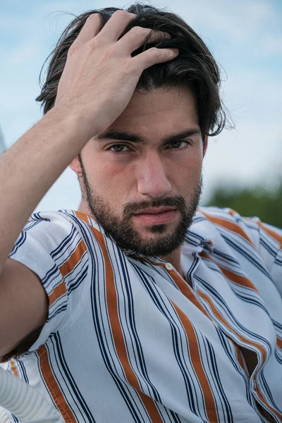 Çizgili gömlekli yakışıklı, koyu renk saçlı adam. Yüksek kalite fotoğraf