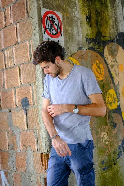 Güzel, siyah saçlı İtalyan çocuk inşaat halindeki fabrikada yürüyor. Yüksek kalite fotoğraf