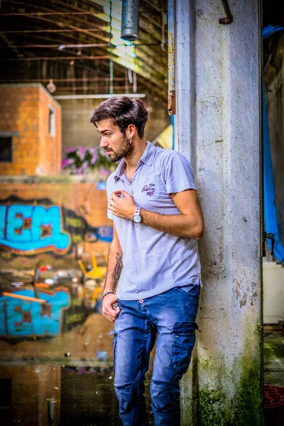 Dejenere olmuş terk edilmiş fabrikadaki yakışıklı siyah saçlı İtalyan adam. Yüksek kalite fotoğraf