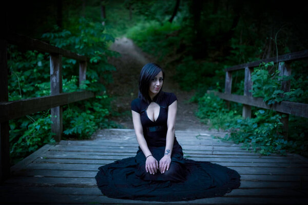 Beautiful brunette Italian girl with dark hair in dark gothic clothes. High quality photo
