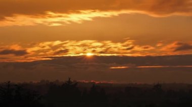 sunset timelapse with sun sweeping behind the clouds. High quality 4k footage