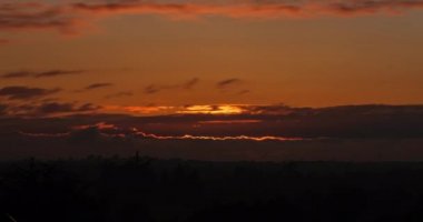 sunset timelapse with sun sweeping behind the clouds. High quality 4k footage