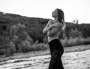 beautiful girl with open back posing on the bank of a river. High quality photo