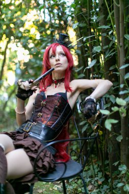 beautiful redheaded steampunk cosplay girl with revolver gun. High quality photo