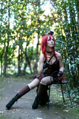 beautiful redheaded steampunk cosplay girl with revolver gun. High quality photo