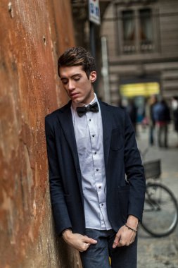handsome guy with jacket and bow tie in city center. High quality photo