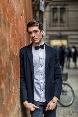 handsome guy with jacket and bow tie in city center. High quality photo