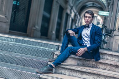 handsome guy with jacket and bow tie in city center. High quality photo