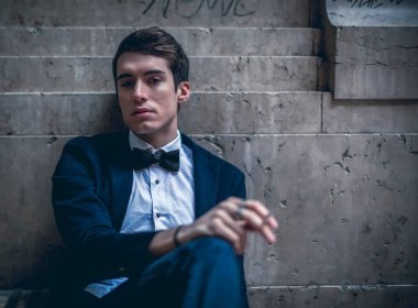 handsome guy with jacket smokes in the city center. High quality photo
