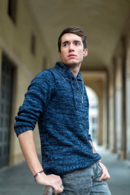 handsome guy with sweater smokes in the city center. High quality photo