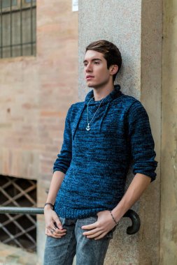 handsome guy with sweater smokes in the city center. High quality photo