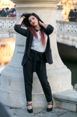beautiful brunette girl standing in front of marble column. High quality photo