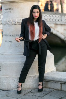 beautiful brunette girl standing in front of marble column. High quality photo