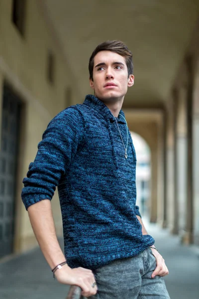 handsome guy with sweater smokes in the city center. High quality photo