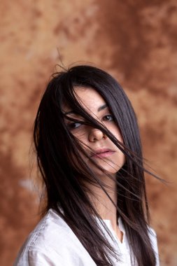 Ocher arka planında güzel İtalyan esmer kız portresi ve uzun saçlar. Yüksek kalite fotoğraf