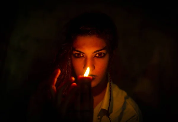 vampire dark goth girl with burning candles in a horror atmosphere. High quality photo