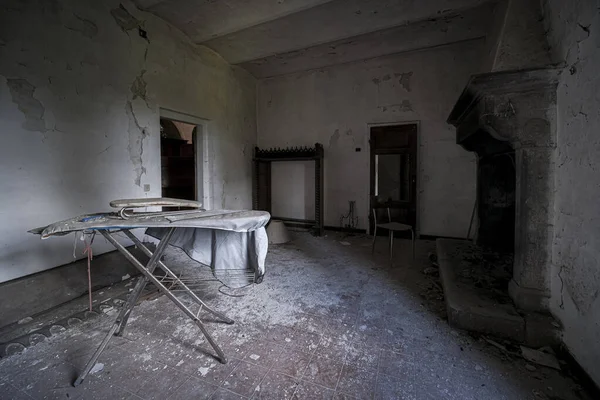 room with fireplace and ironing board in old abandoned large luxurious house. High quality photo