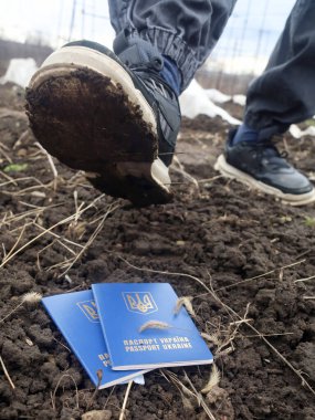 Kavram. Düşmanın botları Ukrayna vatandaşlarının pasaportlarını ezer geçer. Ülkenin işgali. Bölgenin işgali.