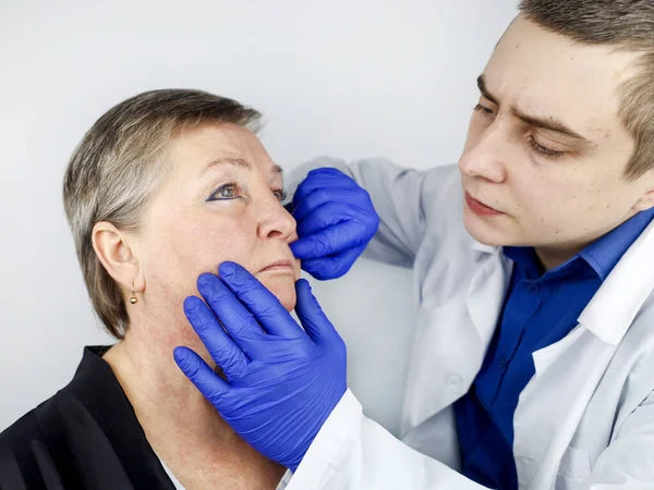 一位老年妇女在一位整形外科医生关于消除与年龄有关的皱纹的咨询会上 古波下巴褶皱 嘴角下垂 面部下部三分之一的矫正 — 图库照片