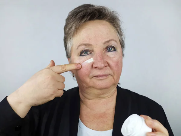 Uma Mulher Idosa Aplica Creme Facial Envelhecimento Cosmetologia Encolhimento Envelhecimento — Fotografia de Stock