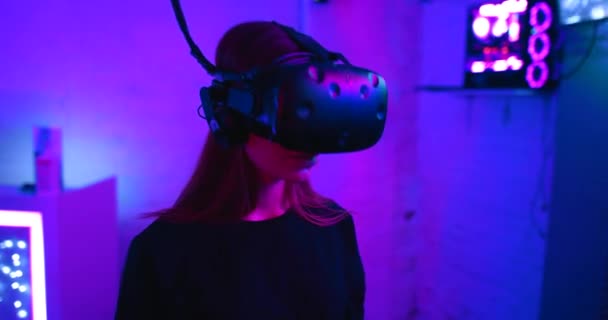 Sala de neón para juegos virtuales. Mujer en casco VR. — Vídeo de stock
