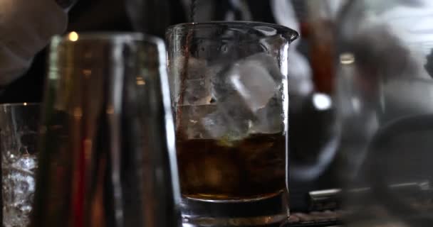 Whisky mit Eis mischen. Der Barkeeper bereitet gekühlten Whisky zu. — Stockvideo