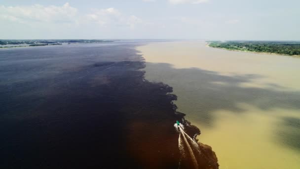 El barco navega en la frontera de dos ríos del Amazonas. La confluencia de dos aguas oscuras y claras del Estrecho Encontro das Aguas y del Estrecho del Río Negro. — Vídeo de stock