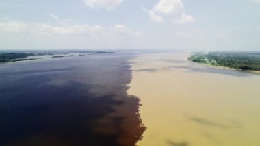 Tekne Amazon 'un iki nehrinin sınırında yelken açıyor. Encontro das Aguas ve Rio Negro Boğazı 'nın iki karanlık ve aydınlık sularının kesişmesi.