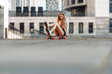 Genç bir kadın sörf tahtasına biniyor.