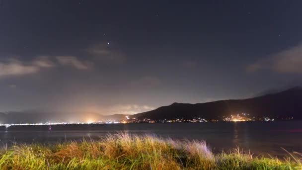 पहाड़ों और जहाजों के साथ पानी को देखते हुए खाड़ी के तट पर रात का समयरेखा . — स्टॉक वीडियो
