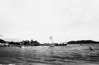 Tropik kıyılara demirlemiş yat ve teknelerin siyah ve beyaz dramatik bir fotoğrafı..