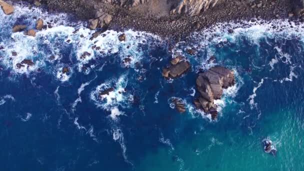 Skalnaté pobřeží s bouřkově modrými vlnami. Horní pohled. — Stock video