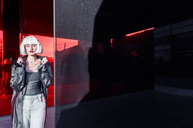 Kırmızı arka planda bir sarışının moda portresi.