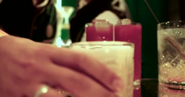 Barman verse un cocktail dans un verre avec une glace à travers le métal en remuant. Processus de fabrication d'un cocktail au bar . — Video