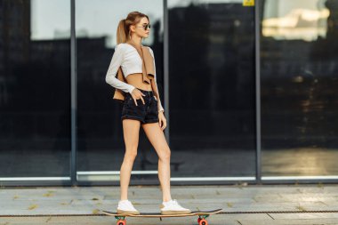 Şehirde kaykaylı bir kadın. Şehirde dolaşan bir kadının güzel, zıt siyah beyaz fotoğrafı..