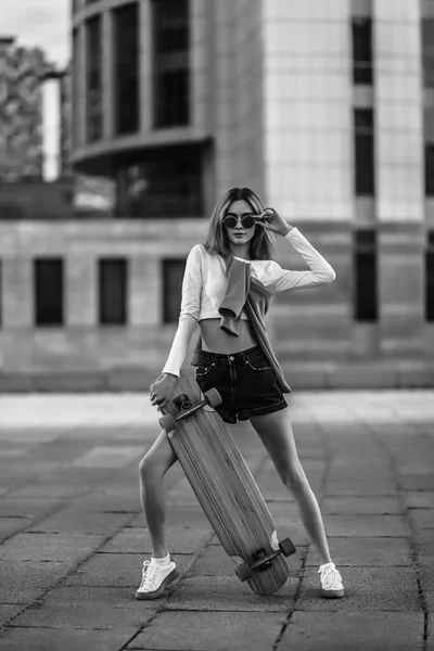 Woman on a skateboard in the city. Beautiful contrasting black and white photo of a woman riding around the city.