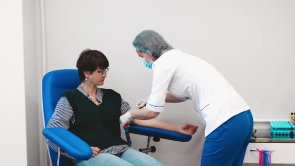 Aplicando um torniquete no braço para tirar sangue. — Vídeo de Stock