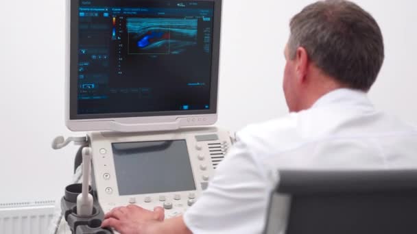 The doctor gives the woman an ultrasound of the thyroid gland. — Video