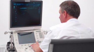The doctor gives the woman an ultrasound of the thyroid gland.