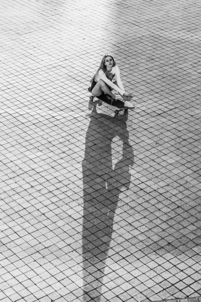市内のスケートボードの女性 街の周りに乗っている女性の美しい対照的な黒と白の写真 高品質の写真 — ストック写真