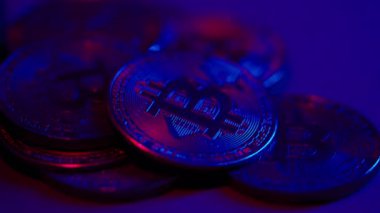 Bitcoin coins under neon light. The currency of the future. High quality 4k footage
