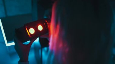 Player puts on 3d virtual reality glasses in neon style. High quality 4k footage