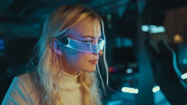 Blonde streamer playing shooter in neon 3D glasses. High quality 4k footage