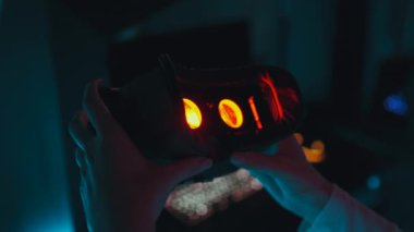 Player puts on 3d virtual reality glasses in neon style. High quality 4k footage