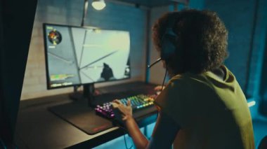 Professional eSports athlete playing shooter in a neon room. High quality 4k footage