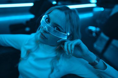 Young woman in neon glasses. Futuristic blonde. High quality photo